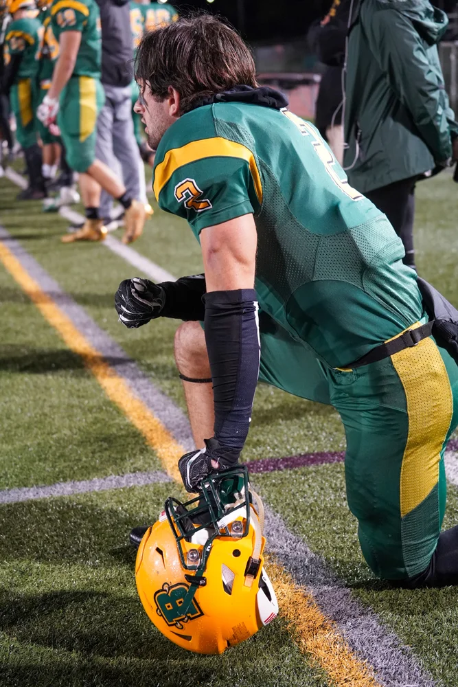 DB taking a knee for Brockport on the sidelines