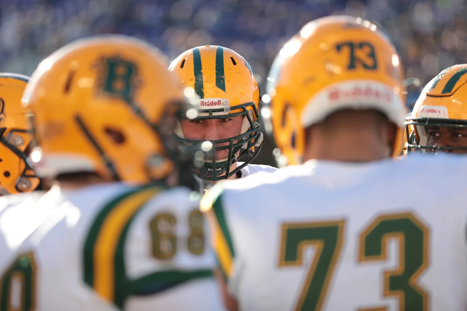 Offensive Lineman listening to coach in the huddle