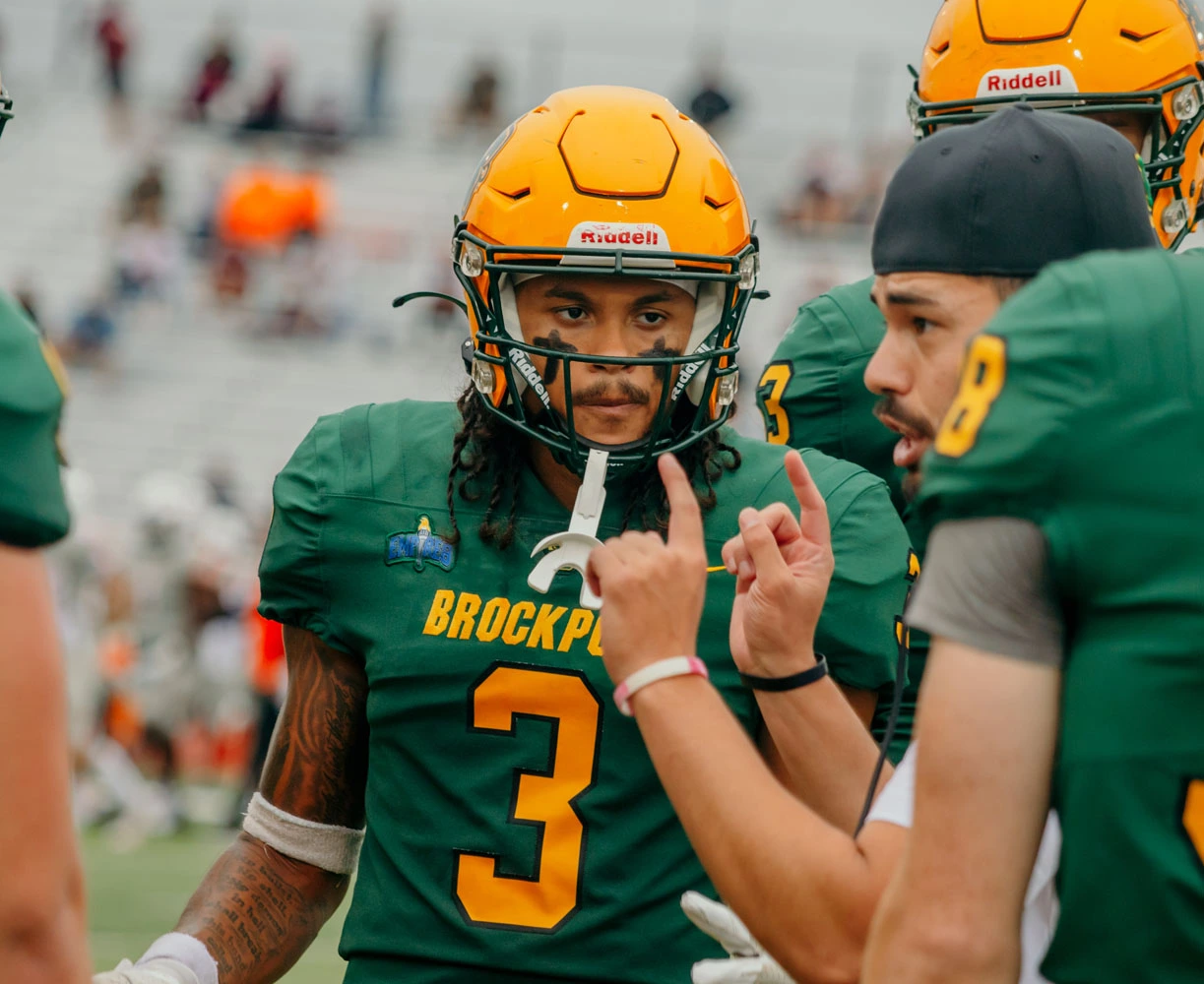 Brockport DB listening to coach during a timeout