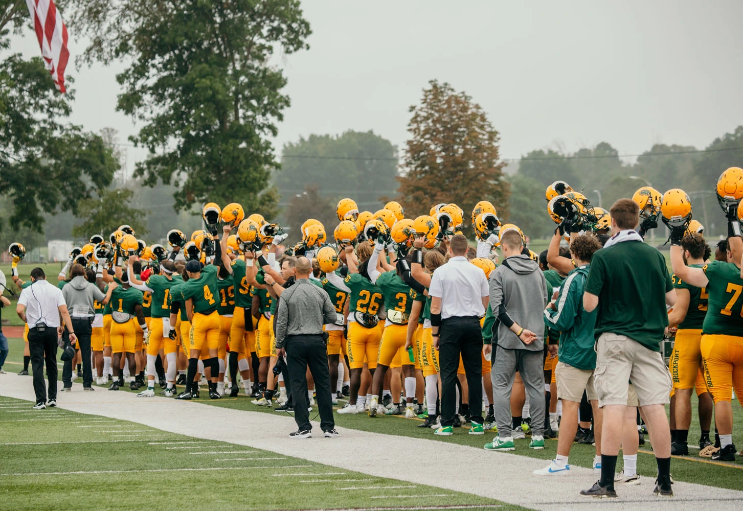 Brockport State Football Holding thier helmets up during the National Anthem